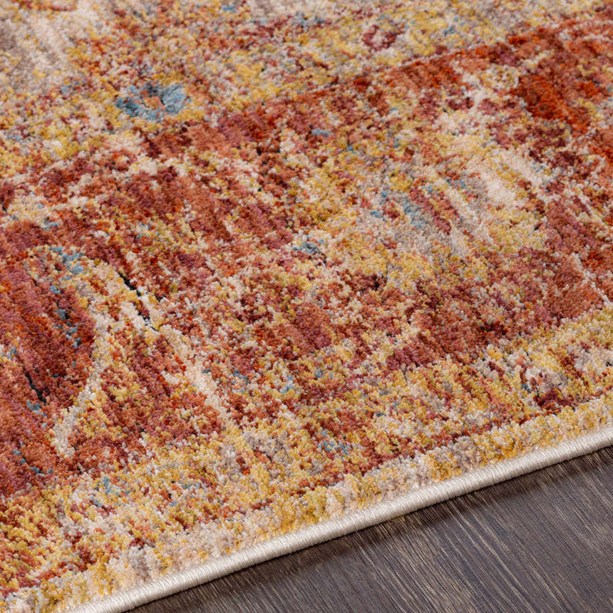 Close-up of the Kilsby Area Rug showing its traditional pattern, warm rust, gold, and blue tones, and soft, textured weave. Texture