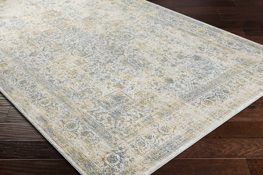 Close-up of the Kintbury Area Rug showing its off-white, blue, and mustard traditional pattern and machine-woven texture. Corner