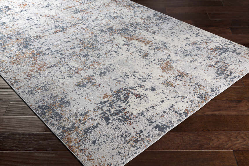 Close-up of Kearny Area Rug, a contemporary rug in brick red, brown, charcoal, and light gray on dark wood floors. Corner