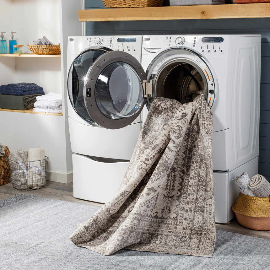 Laundry room scene with Ladybrand Washable Area Rug being washed in a white washing machine. Gray rug on floor. Washing-Machine