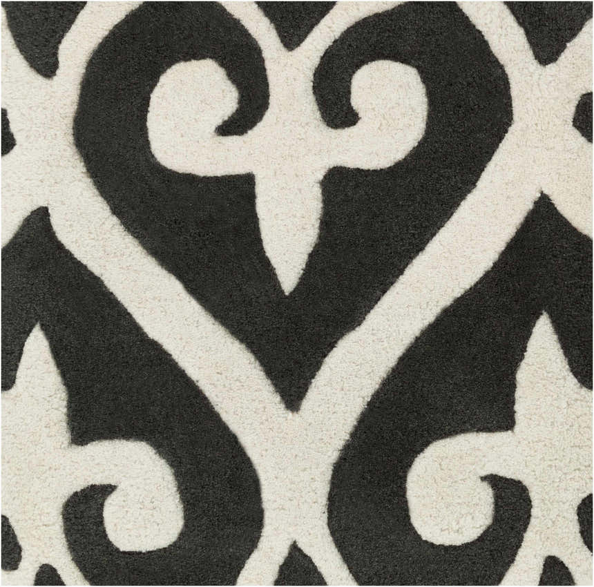 Close-up of the Landa Area Rug, a hand-tufted rug in black and cream with a contemporary, swirling pattern. 100% NZ Wool. Swatch