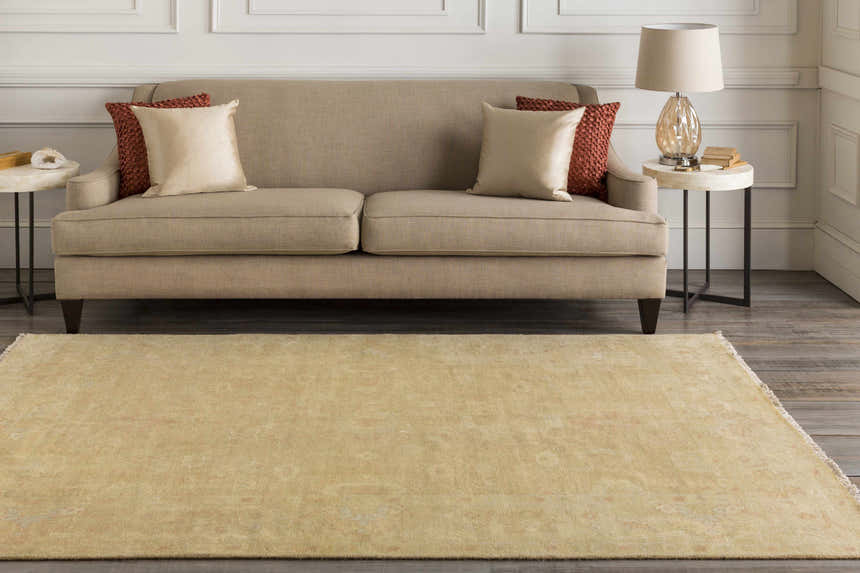Living room scene with a tan sofa, side tables, and the Langhorne Carpet in a muted tan color. Roomscene-Rectangle