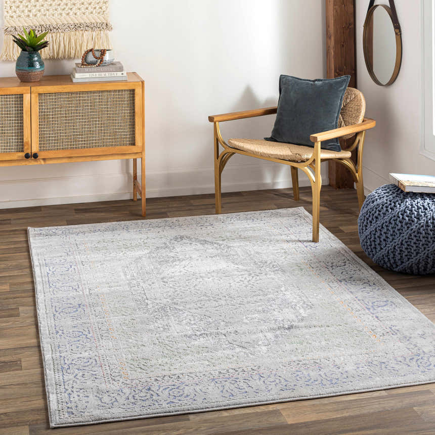 Living room scene with Laplace Area Rug in blue, charcoal, and gray. Farmhouse style with wood cabinet and chair. Roomscene-Rectangle