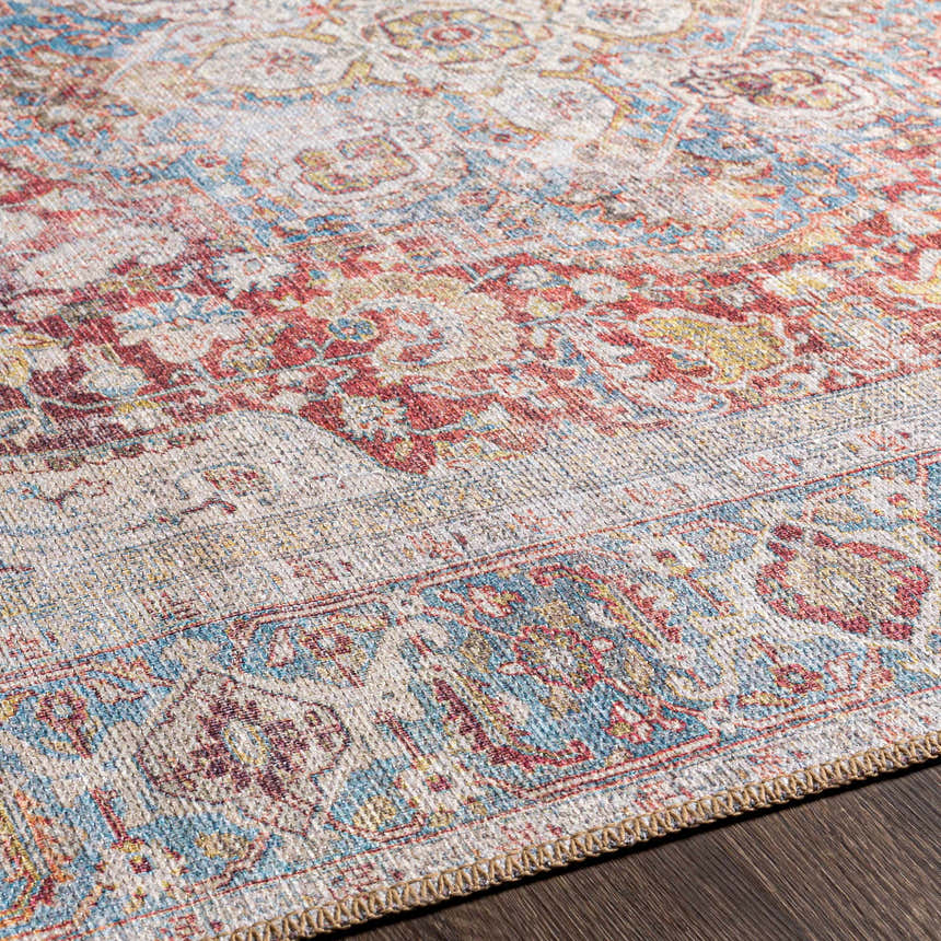 Close-up of the Cream Rust Leeston Washable Rug, showing its brick red, cream, and light blue vintage-style pattern. Texture