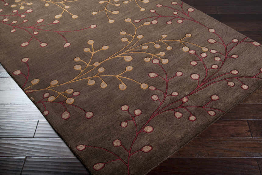 Close-up of the Brown Elsu Area Rug, a hand-tufted wool rug with a floral pattern in brown, burgundy, and gold. Corner