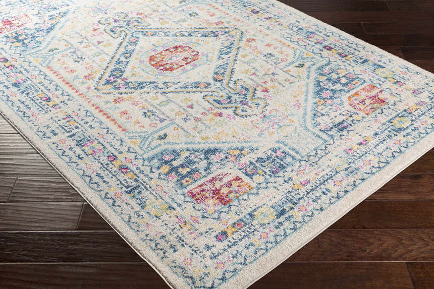 Close-up of the Leslie Area Rug; a farmhouse-style runner with aqua, burnt orange, and navy accents on an off-white base. Corner