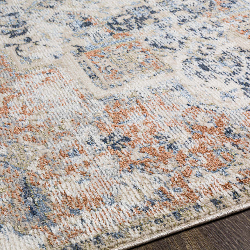 Close-up of the Loughrea Area Rug featuring brick red, cream, denim, and gray tones on a textured, machine-woven design. Texture
