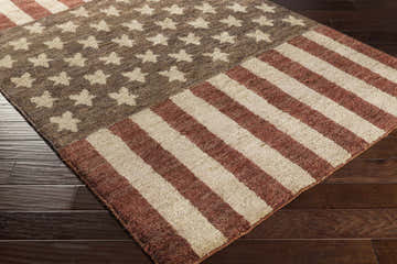 Close-up of the Lakemoor Area Rug. Design features beige stars and rust stripes on a brown jute rug. Corner
