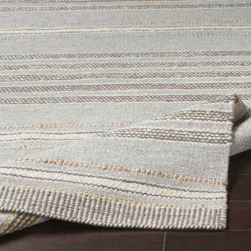 Close-up of the Allendorf Area Rug showing beige, cream, and charcoal horizontal stripes and hand-woven texture. Fold