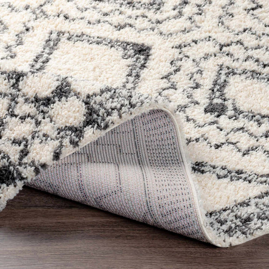 Close-up of the Lloydminster Area Rug showing the black and cream shag texture and Moroccan-inspired pattern. Fold