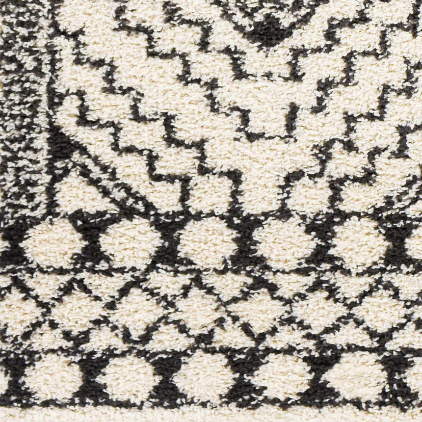 Close up of the Lloydminster Area Rug, showing its black and cream shag texture and Moroccan-inspired geometric pattern. Swatch