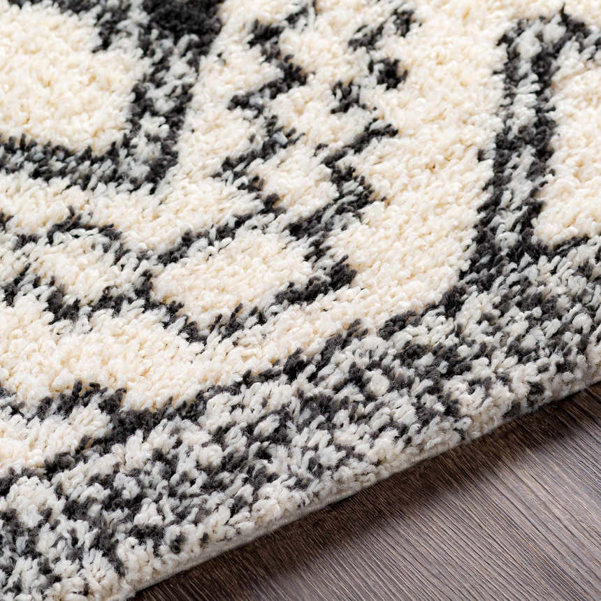Close up of the black and cream Lloydminster Area Rug, a shag rug with a Moroccan-inspired pattern. Texture