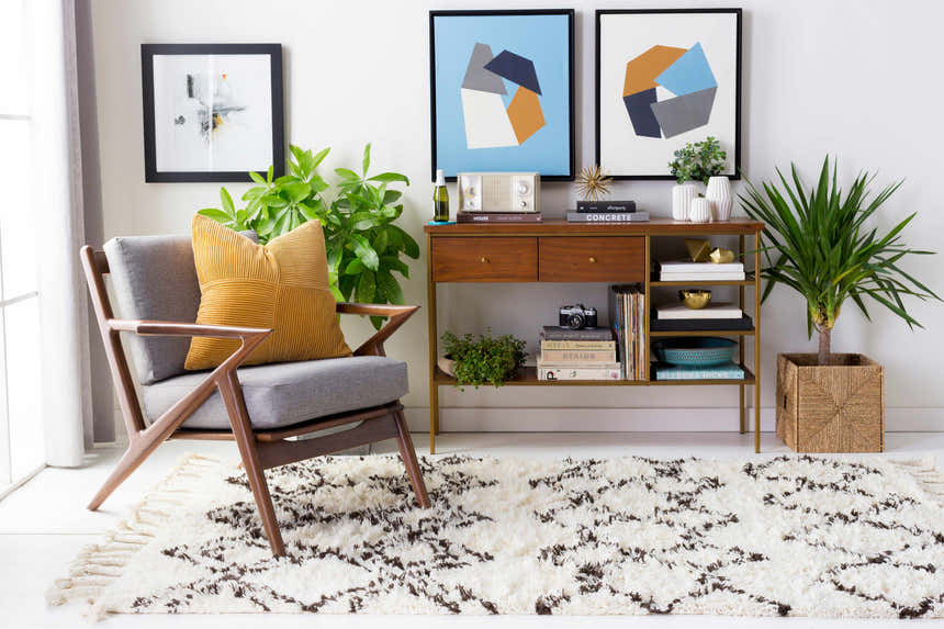 Living room scene with a charcoal and ivory Lothian Area Rug, gray chair, and mid-century modern console table. Roomscene-Rectangle