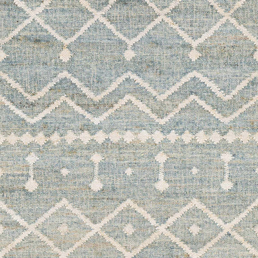 Close-up of the Lowville Jute Rug. Hand-woven jute rug in dusty sage with ivory geometric diamond and zig-zag patterns. Swatch