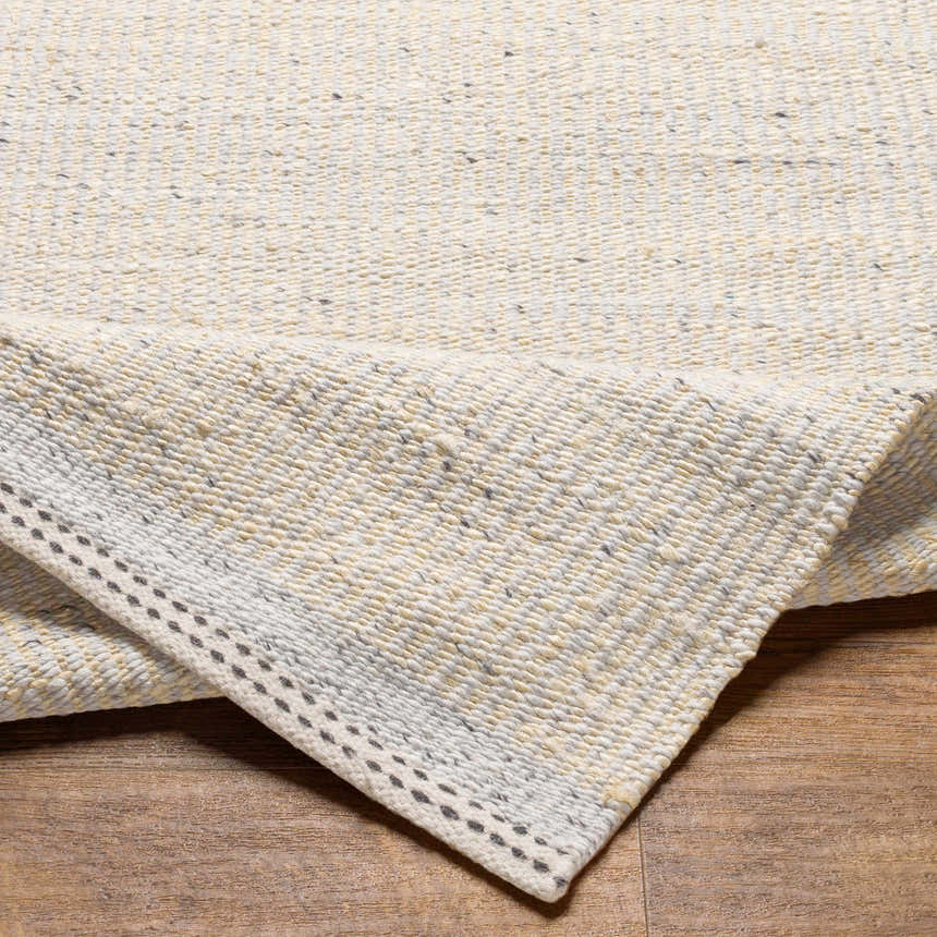 Close-up of the hand woven Lumatil Area Rug. Jute and wool rug in cream, light beige, and gray tones. Farmhouse style. Fold