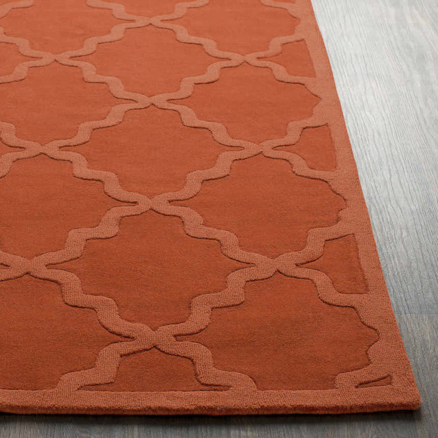 Close-up of the bright orange Lyoth Area Rug showing the hand-loomed wool texture and contemporary quatrefoil pattern. Front