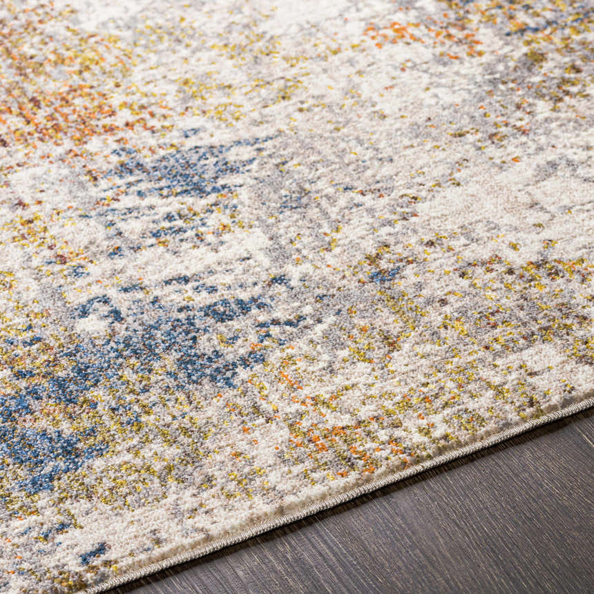 Close-up of Macayug Area Carpet showing cream, blue, gray, mustard, olive, and rust colors and soft, textured weave. Texture