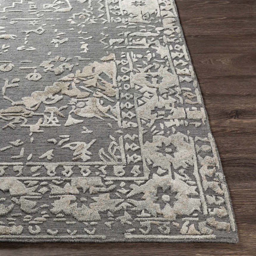 Close-up of the Macgregor Area Rug showing its charcoal base and light gray, hand-loomed, bohemian-inspired pattern. Front