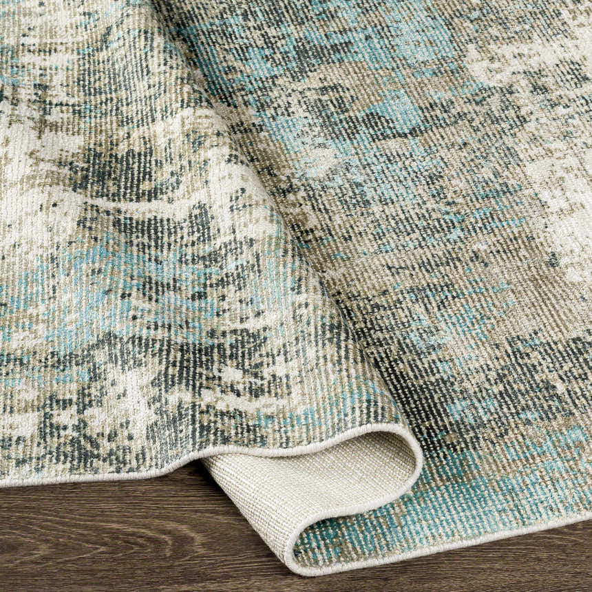 Close-up of the hand-knotted Machen Area Rug. Beige, ice blue, and gray contemporary design with wool and viscose texture. Fold