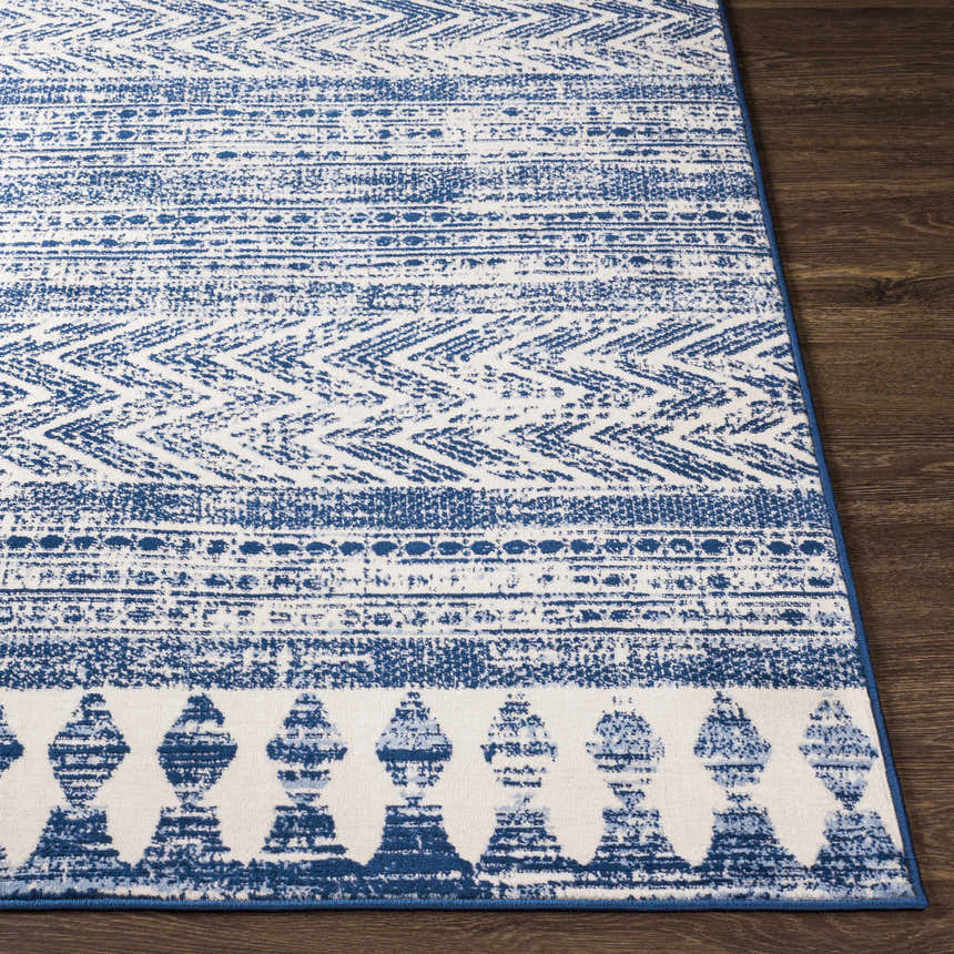 Close up of Mahinog Area Carpet. Light blue and off white rug with a bohemian-inspired geometric pattern. Front
