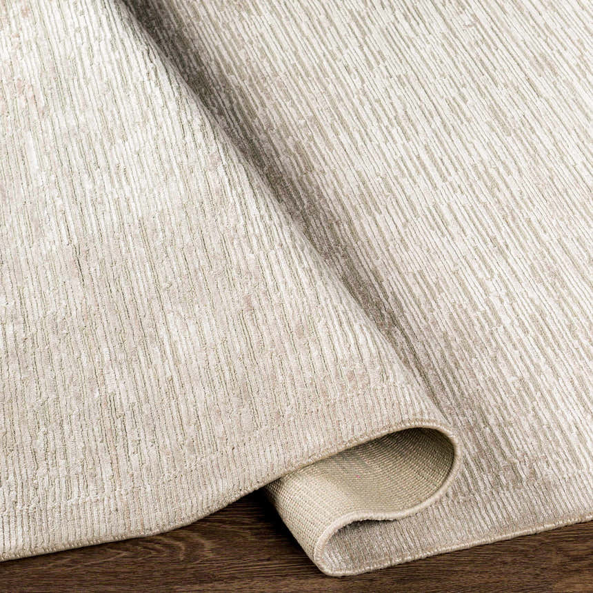 Close-up of the hand-knotted Mardi Area Rug. Charcoal and light beige wool and silk rug with a contemporary design. Fold