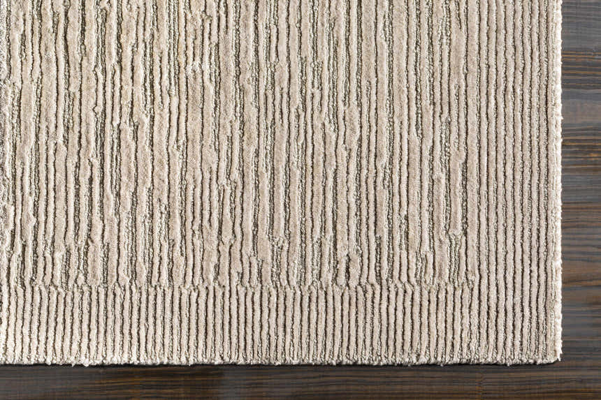 Close-up of the hand-knotted Mardi Area Rug. Charcoal and light beige wool and silk with a contemporary striped design. Corner