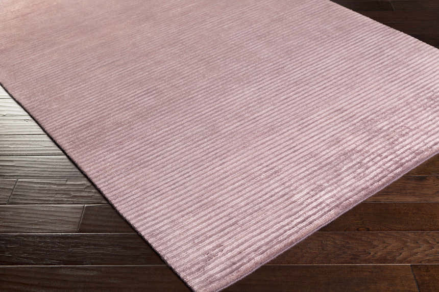 Close-up of the Meador Area Carpet in burgundy and dark purple, featuring a subtle striped pattern. Corner