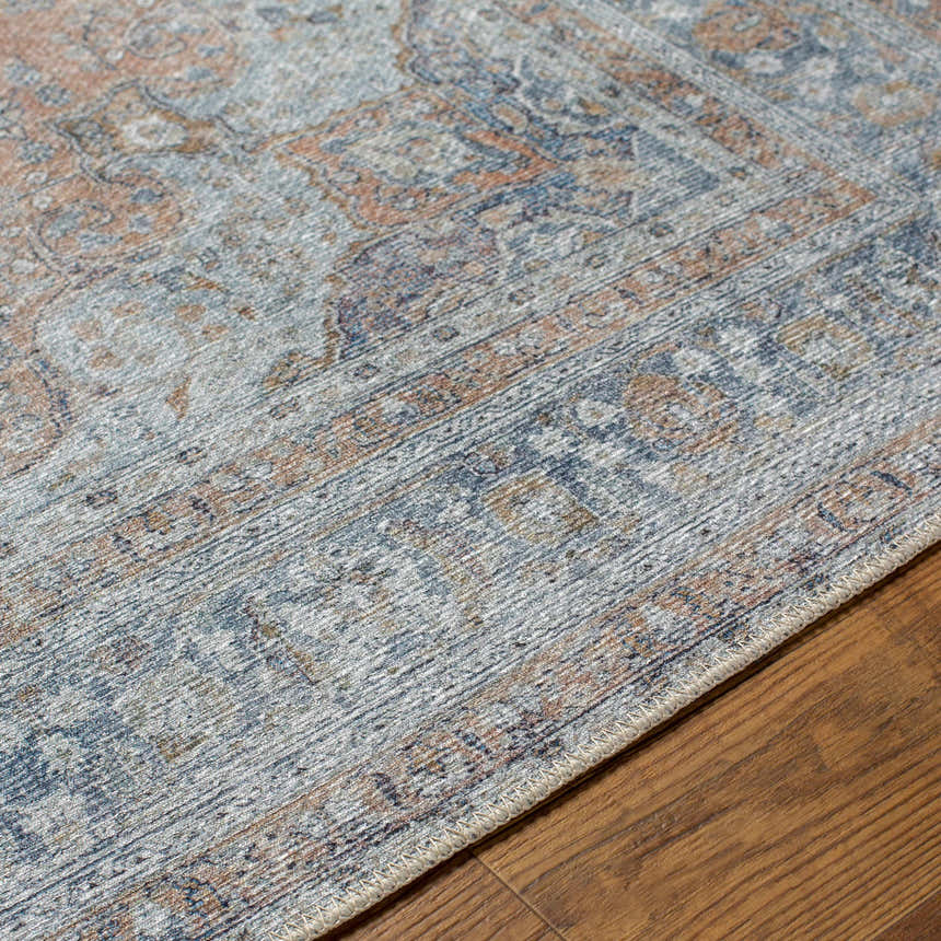 Close-up of the Mianay Washable Area Rug showing its beige, blue, and light gray vintage-style pattern and machine-woven texture. Texture
