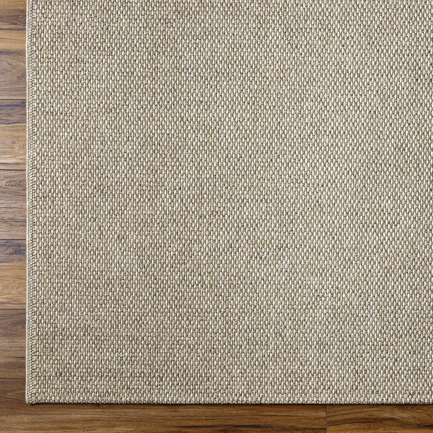 Close-up of the woven texture and pattern of the Matah Beige Outdoor Area Rug on dark wood flooring. Corner