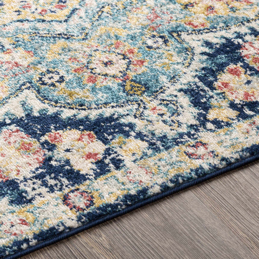 Close-up of the Mallacoota Area Rug showcasing its cream, blue, pink, and yellow traditional floral pattern. Texture
