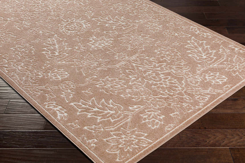 Close-up of a Maninihon 3D Outdoor Area Rug. Clay-colored rug with an off-white floral pattern on dark wood flooring. Corner