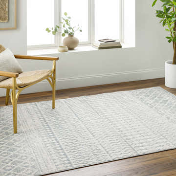 Light gray Morey Area Rug in a bright living room with wood floors, a chair, and a large window. Roomscene-Rectangle