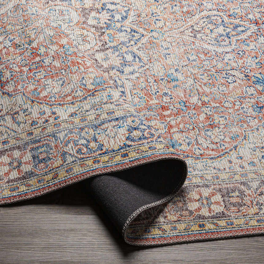 Close-up of the Cream Rust Maribojoc Medallion Washable Area Rug showing its oriental design, rust, cream, and blue colors. Fold