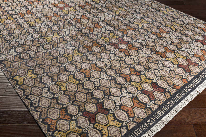 Close-up of the Mercersburg Carpet showing a geometric pattern in black, orange, beige, brown and red. Corner