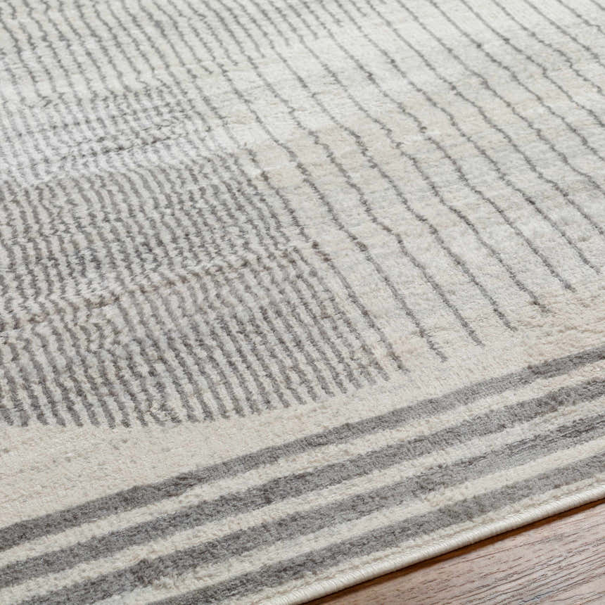 Close-up of the Amar Area Rug showing its geometric stripe pattern in dark gray, gray, and natural gray hues. Texture