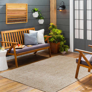 Outdoor patio scene with Epson Dark Beige Indoor Outdoor Area Rug, wood furniture, and gray wood paneled wall. Roomscene-Rectangle