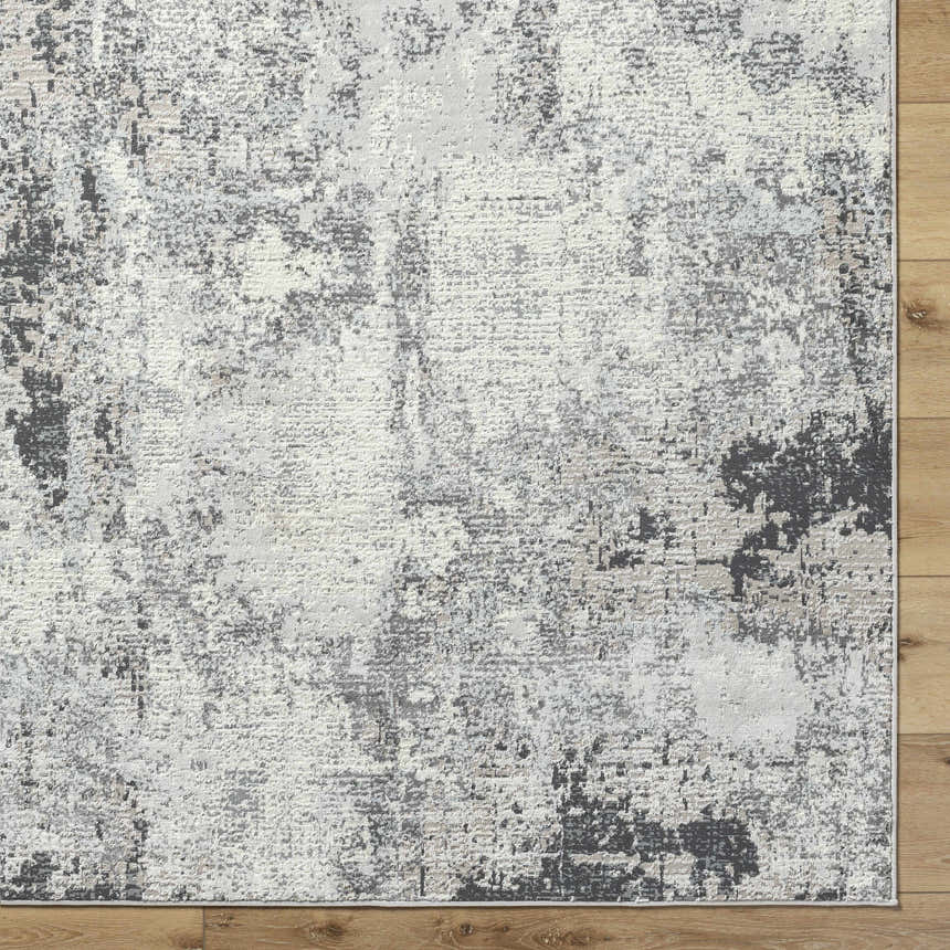 Close-up of the Marci Area Rug showcasing its charcoal, cream, and gray Southwestern design and textured, machine-woven construction. Corner