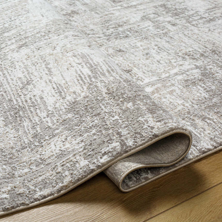 Close-up of the Nannyville Area Rug. Bone, gray, and ivory tones create a contemporary abstract pattern and soft texture. Fold