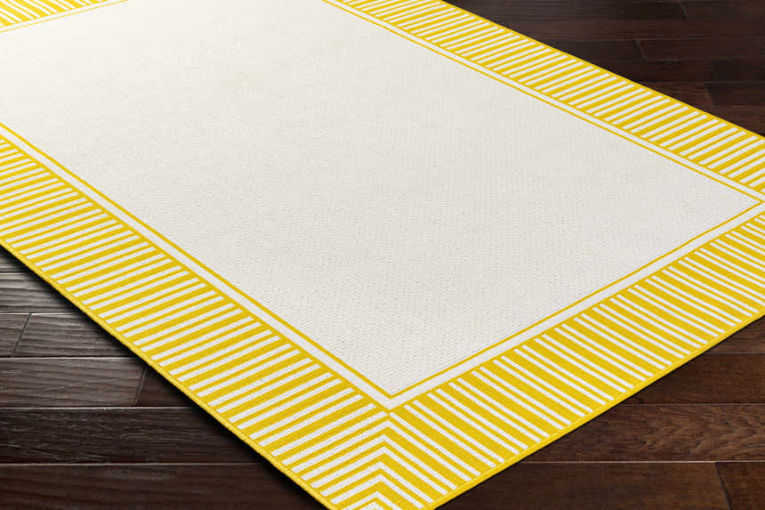 Close-up of the Nadir Area Rug. Cream rug with a bright yellow and white striped border. Farmhouse style. Corner