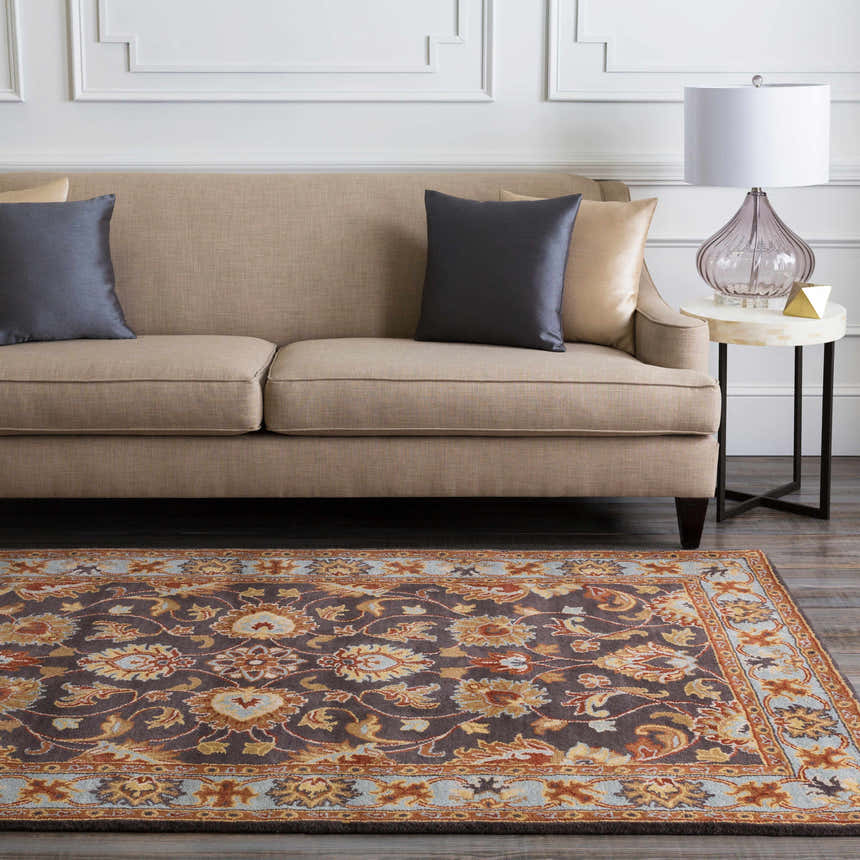 Living room scene with a beige sofa and the Cherryfield 1004 wool rug in beige, burnt orange, and slate blue tones. Roomscene-Rectangle