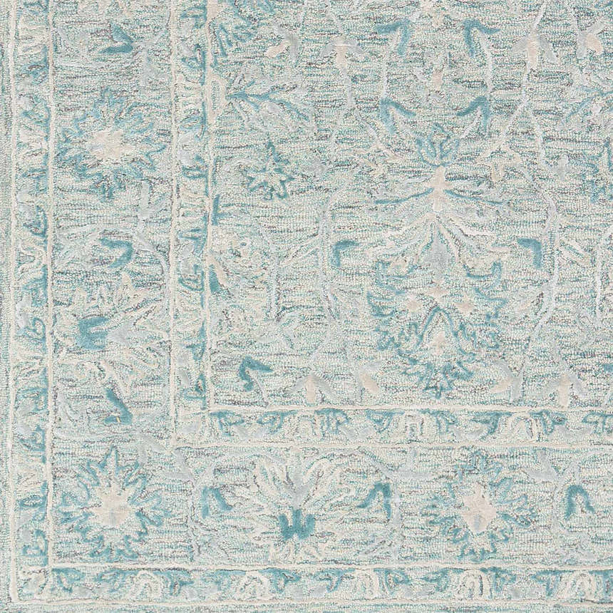 Close-up of the Neavitt Wool & Faux Silk Rug in aqua and light beige, featuring a traditional floral pattern. Hand-tufted texture. Swatch