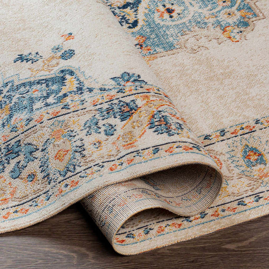 Close-up of the rolled Neepawa Area Carpet. Cream rug with blue, orange, and brown traditional-style pattern. Fold
