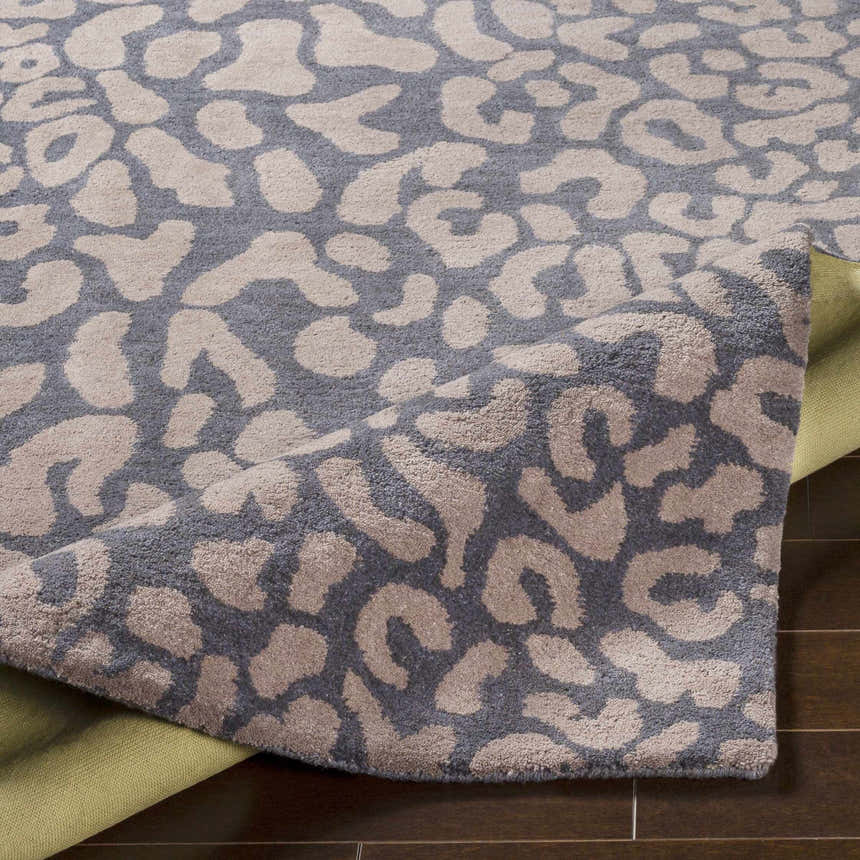Close up of the gray Neoma Animal Print Wool Rug showing the contemporary animal pattern and hand tufted texture. Fold