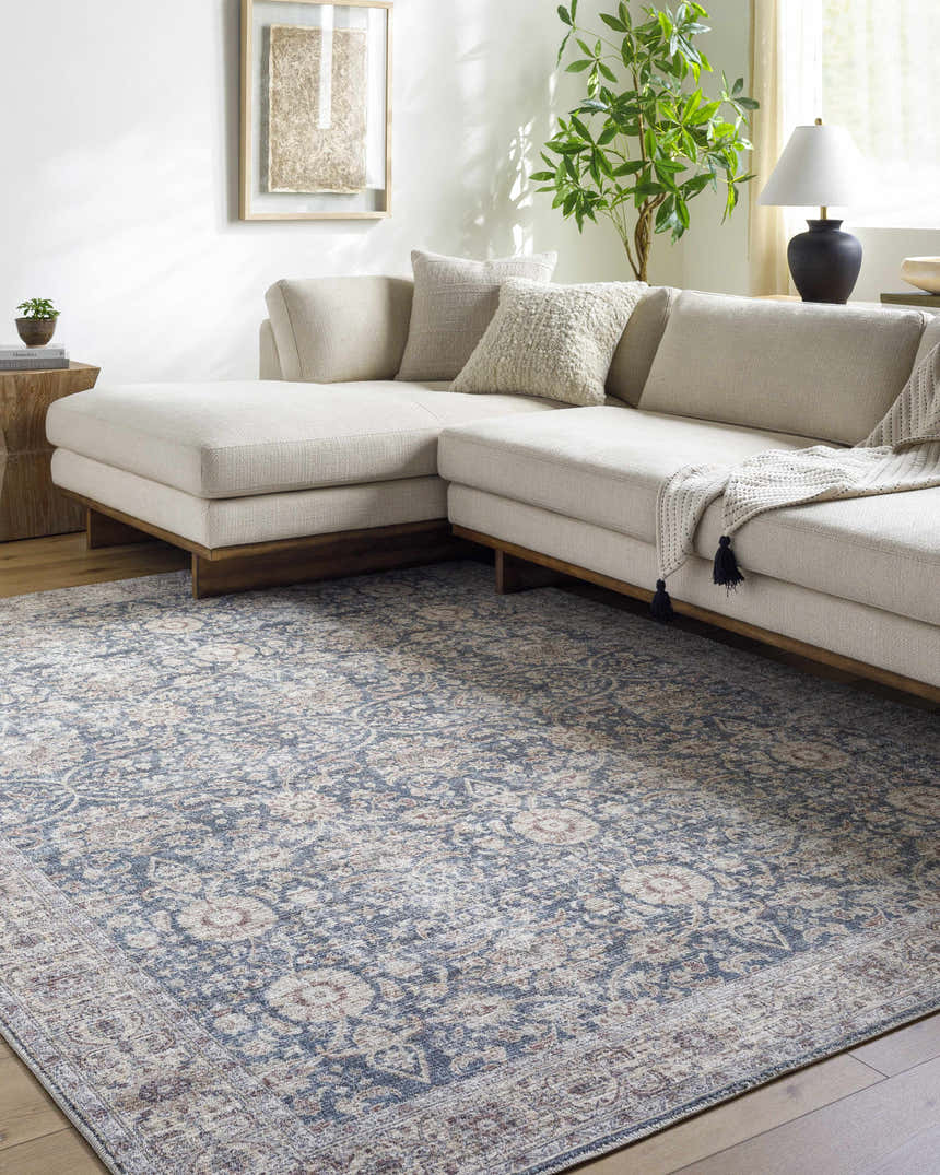 Living room scene with a beige sectional sofa and the Nnena Area Rug in beige, black, dark red, and rust. Roomscene-Rectangle
