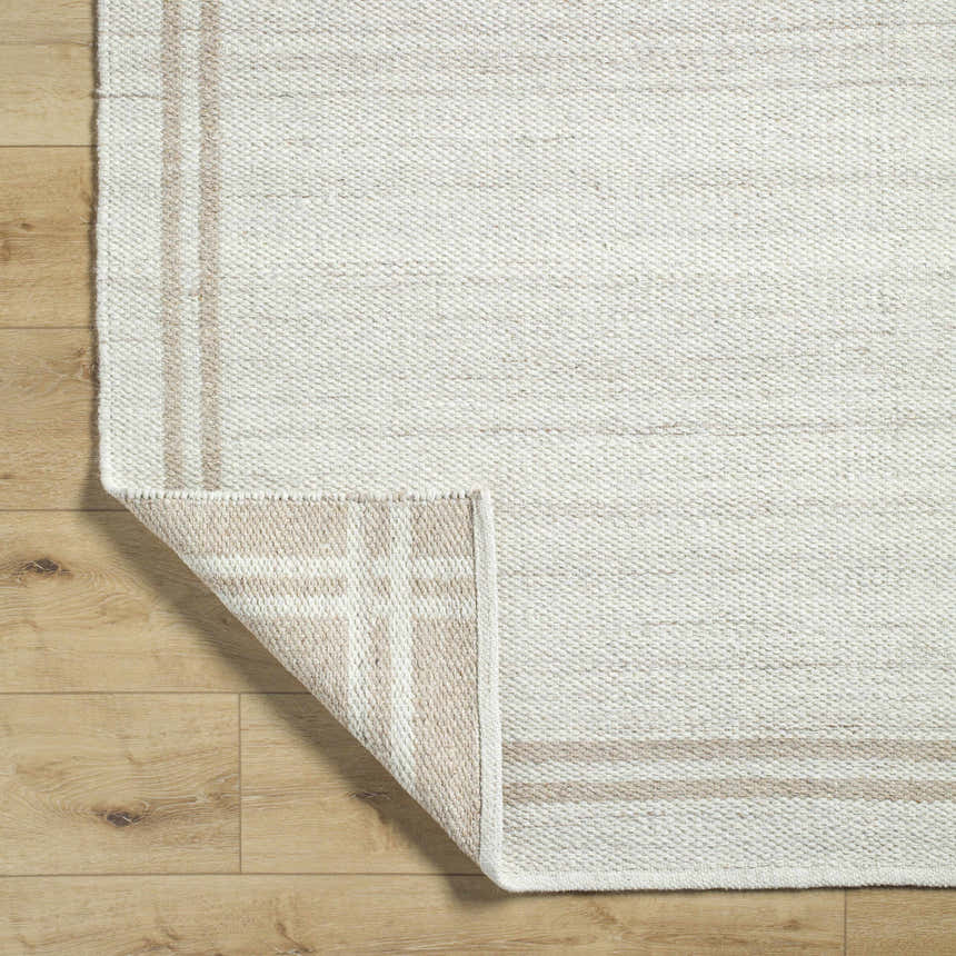 Close-up of the hand woven Nimue Area Rug. Ivory and tan wool rug with a farmhouse style. Fold