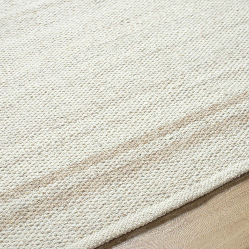 Close-up of the hand-woven Nimue Area Rug. Ivory and tan wool rug with subtle stripe pattern and textured weave. Texture