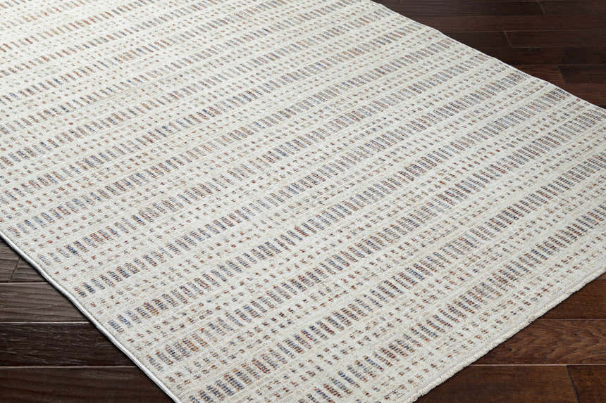 Close-up of Nuhad Area Rug featuring a contemporary geometric pattern in dark red, gray, navy, rust, and white. Corner