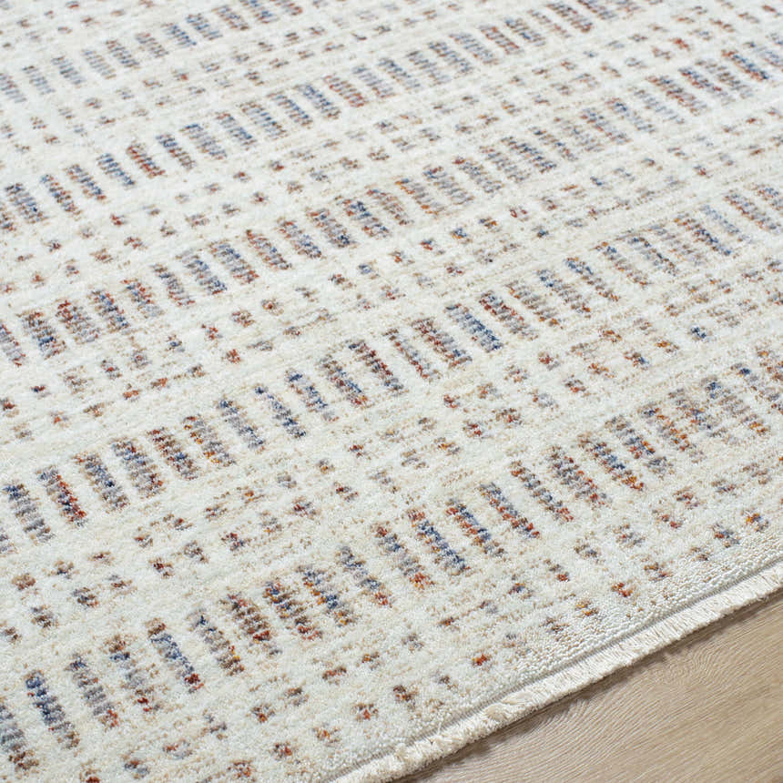 Close-up of the Nuhad Area Rug with a contemporary geometric pattern in dark red, gray, navy, rust, and white. Texture