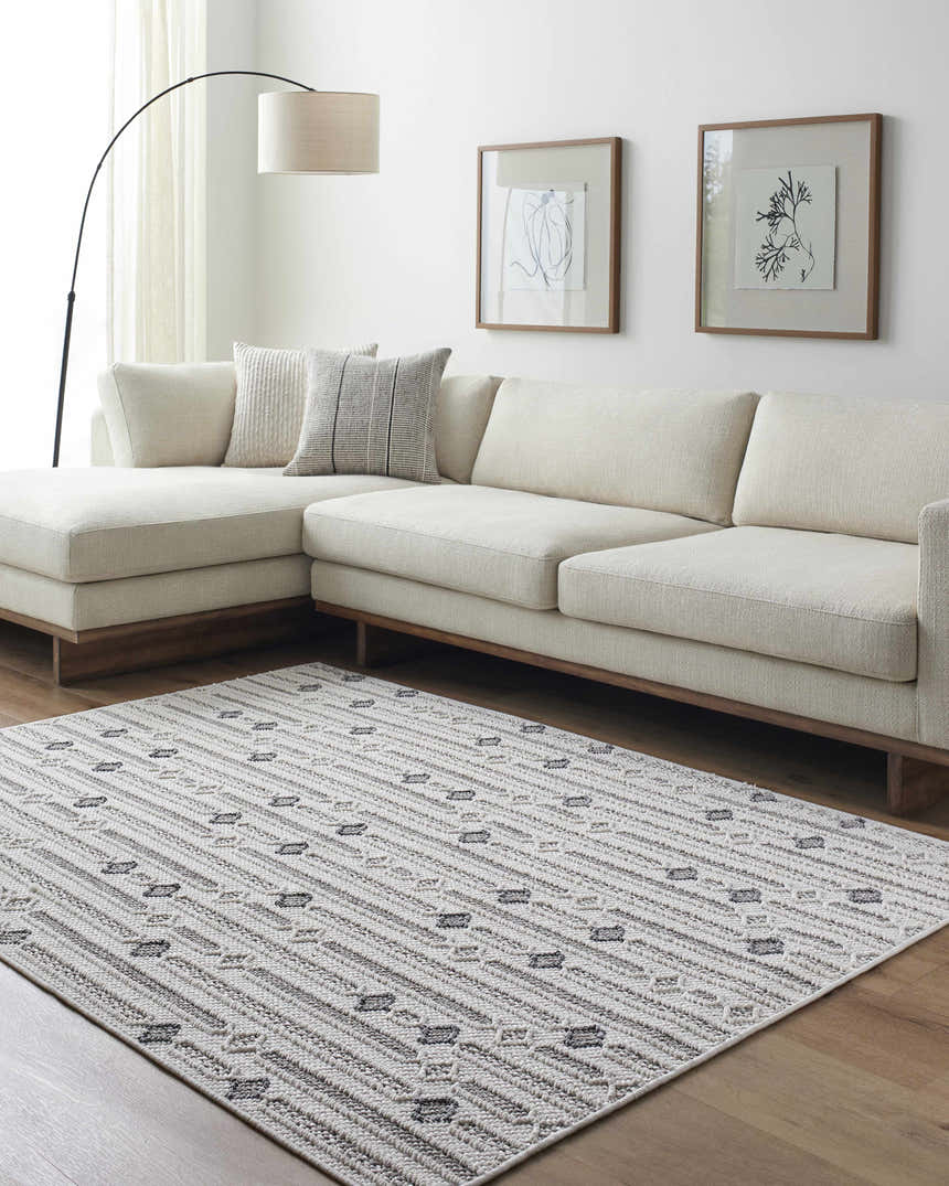 Living room scene with ivory sofa and Niara Area Rug in ivory, light gray, and medium gray. Roomscene-Rectangle