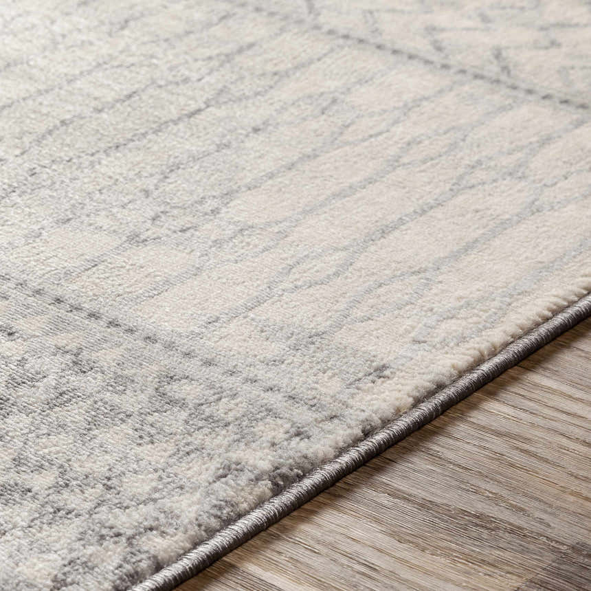 Close-up of the Nunda Gray Rug showing its ivory and silver gray geometric pattern and soft, textured polypropylene weave. Texture
